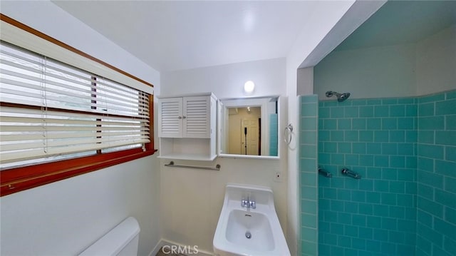 bathroom with toilet and tiled shower