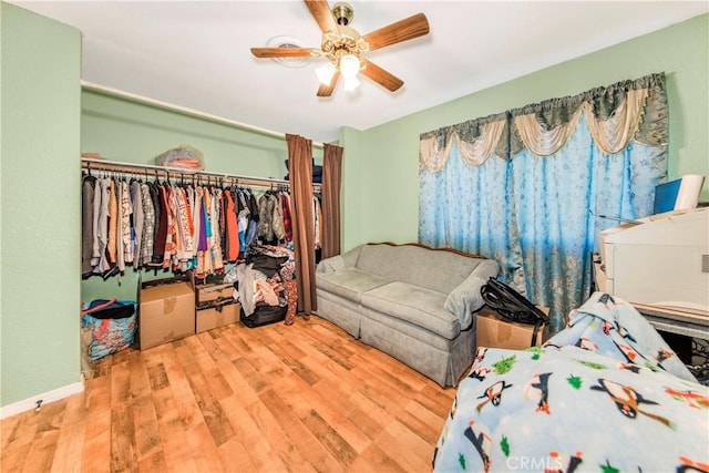 bedroom with ceiling fan, a closet, and wood finished floors