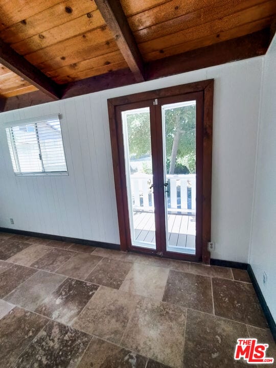 entryway with wooden walls, beamed ceiling, and wooden ceiling