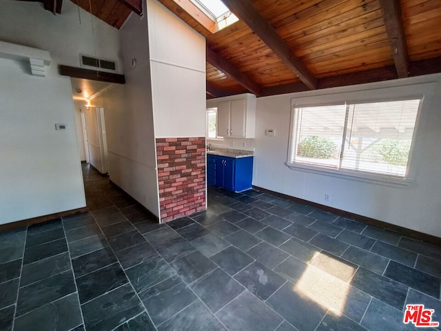 interior space featuring a skylight, beamed ceiling, wood ceiling, and high vaulted ceiling