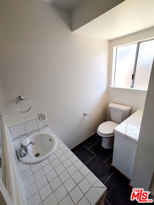 bathroom featuring tile patterned floors, vanity, and toilet