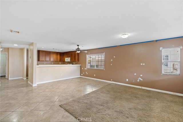 unfurnished living room featuring light tile patterned floors and ceiling fan