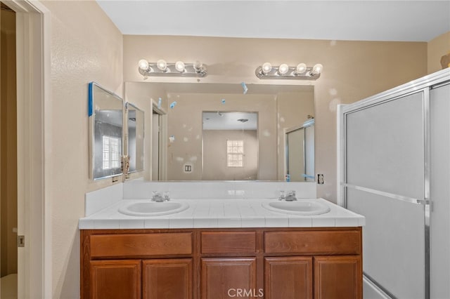 bathroom featuring vanity and a shower with door