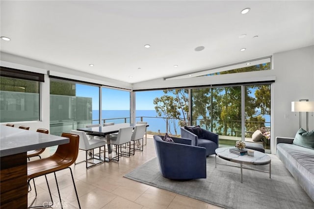 tiled living room featuring plenty of natural light, a water view, and vaulted ceiling