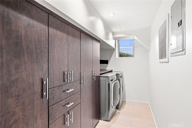 clothes washing area with cabinets, independent washer and dryer, and light tile patterned flooring