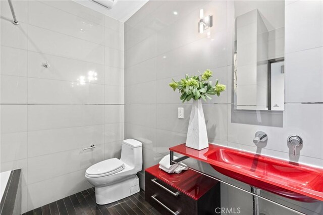 bathroom featuring toilet and tile walls