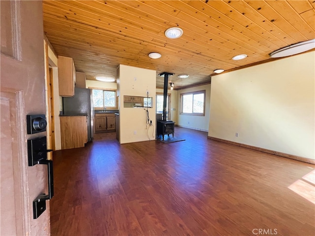 kitchen with wood ceiling, a wood stove, and plenty of natural light