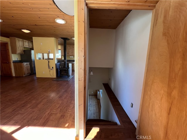 staircase with a wood stove, wood-type flooring, and wooden ceiling