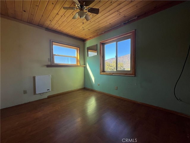 spare room featuring ceiling fan, a mountain view, wooden ceiling, and hardwood / wood-style floors