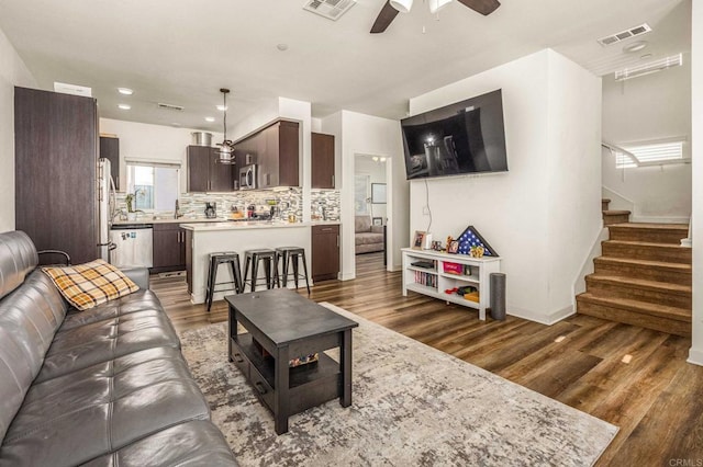 living room featuring dark wood-type flooring and ceiling fan