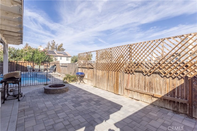 view of patio with a fenced in pool and a fire pit