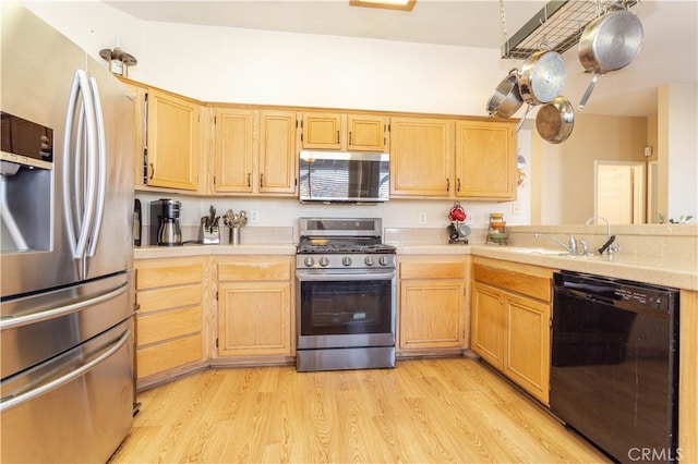 kitchen featuring light hardwood / wood-style floors, light brown cabinets, stainless steel appliances, and sink