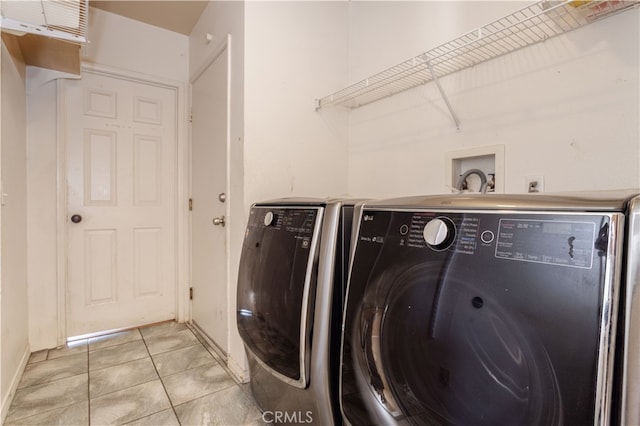 washroom featuring washing machine and dryer and light tile patterned flooring