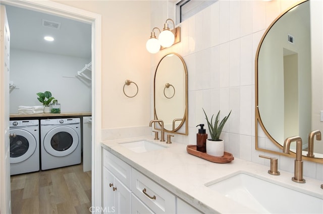 bathroom featuring vanity, washing machine and clothes dryer, and hardwood / wood-style flooring