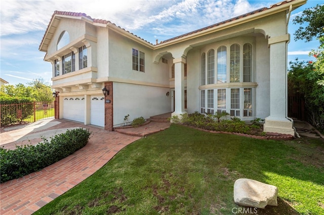 mediterranean / spanish house featuring a front yard and a garage