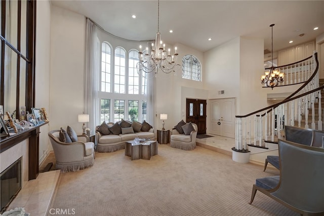 carpeted living room with an inviting chandelier, a tile fireplace, and a high ceiling