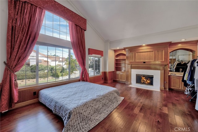 bedroom featuring ornamental molding, dark wood-type flooring, and multiple windows