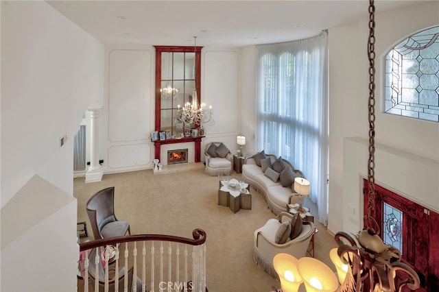 carpeted living room featuring an inviting chandelier