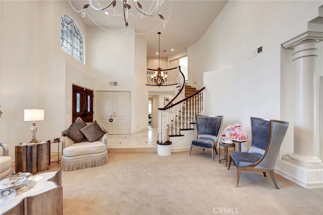 living area featuring an inviting chandelier, light colored carpet, a high ceiling, and decorative columns