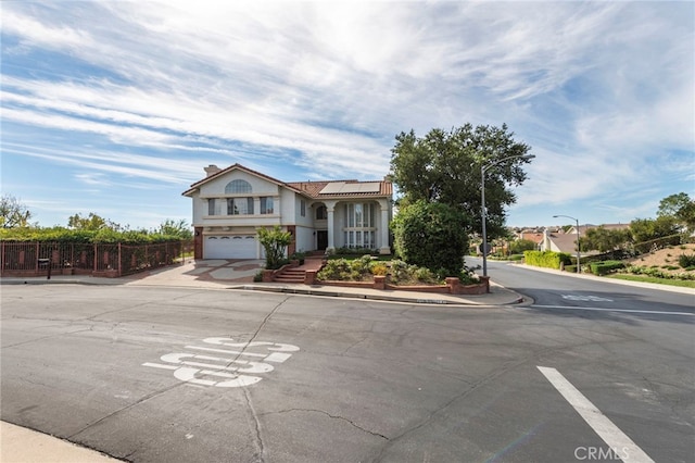 view of front of property featuring solar panels and a garage