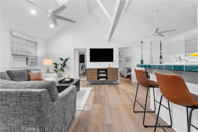 living room featuring ceiling fan, light wood-type flooring, and high vaulted ceiling