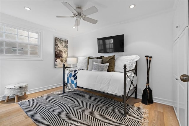 bedroom with hardwood / wood-style flooring, ceiling fan, and crown molding