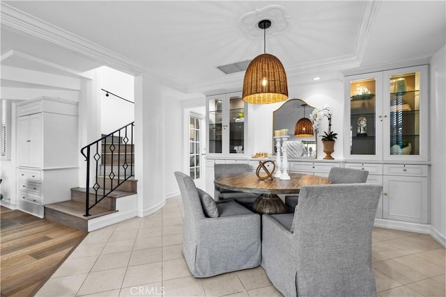 dining room with light wood-type flooring and crown molding