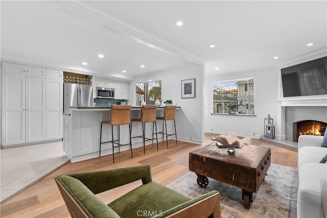 living room with light hardwood / wood-style floors and ornamental molding