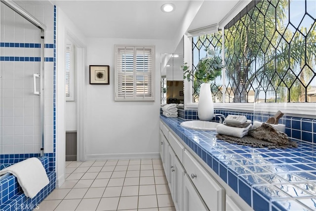 bathroom with tile patterned flooring, vanity, and a shower with door