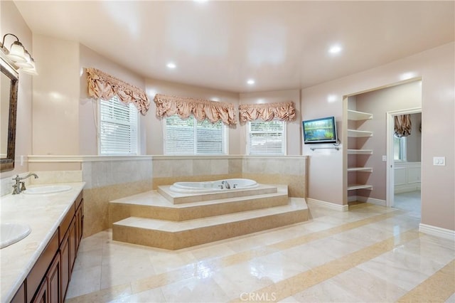 bathroom with vanity and tiled bath