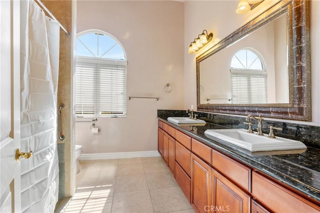 bathroom featuring tile patterned flooring, vanity, a healthy amount of sunlight, and toilet