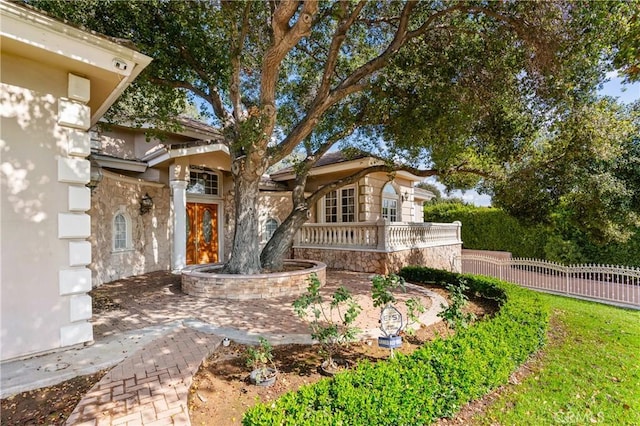 exterior space featuring stone siding and fence