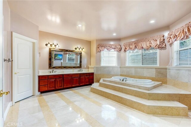 bathroom featuring vanity, tile patterned floors, and tiled tub