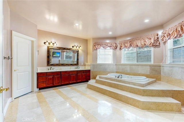 bathroom with vanity and tiled tub