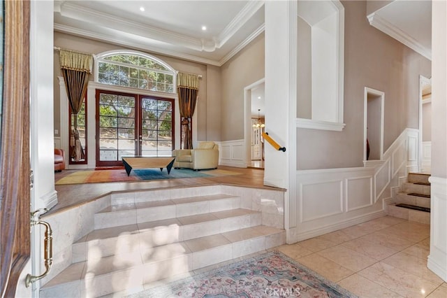 interior space featuring a tray ceiling, ornamental molding, and french doors