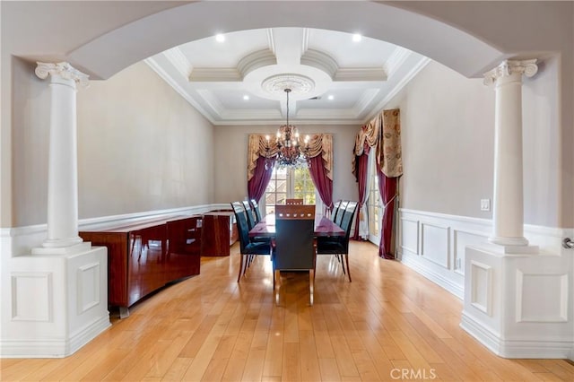 dining space with coffered ceiling, a notable chandelier, decorative columns, and light wood-type flooring