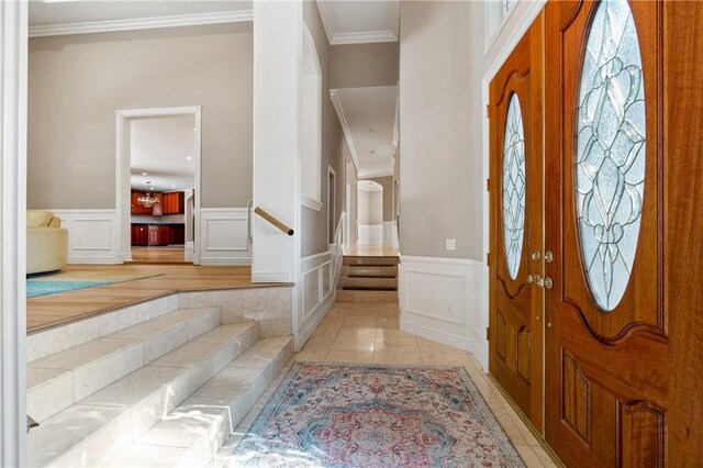 tiled foyer featuring crown molding