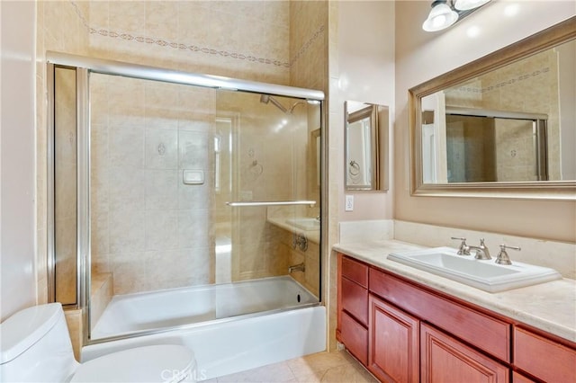 full bathroom featuring shower / bath combination with glass door, tile patterned floors, vanity, and toilet