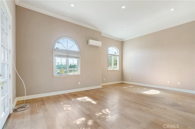 empty room with a wall mounted air conditioner, crown molding, and light hardwood / wood-style floors