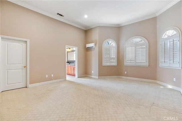 spare room with light colored carpet, a wealth of natural light, and crown molding