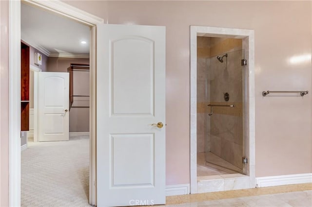 bathroom with crown molding and a shower with shower door