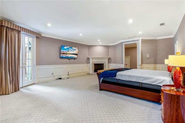 bedroom with ornamental molding, a fireplace, and light carpet