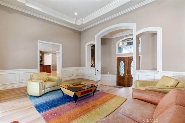 interior space featuring an inviting chandelier, wood-type flooring, a tray ceiling, and crown molding