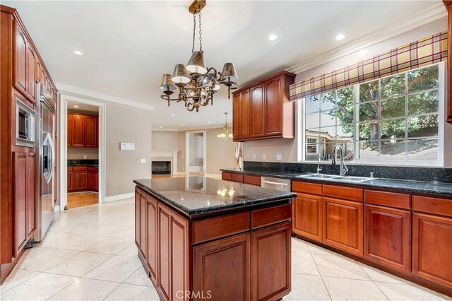 kitchen featuring crown molding, sink, decorative light fixtures, a chandelier, and a center island