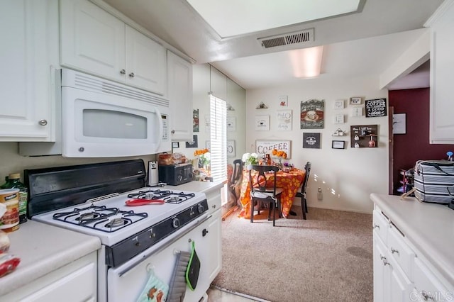 kitchen with white appliances, light carpet, and white cabinetry