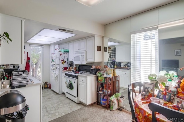 kitchen featuring white appliances, white cabinetry, and decorative backsplash