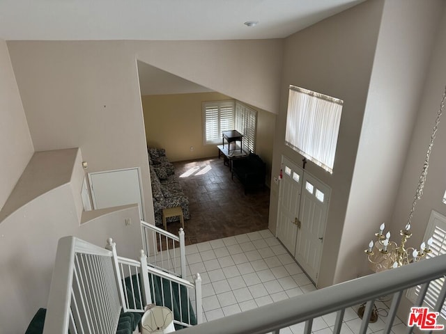 tiled entryway with a notable chandelier and high vaulted ceiling