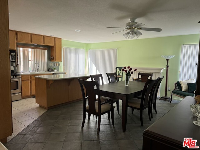 tiled dining area with sink and ceiling fan