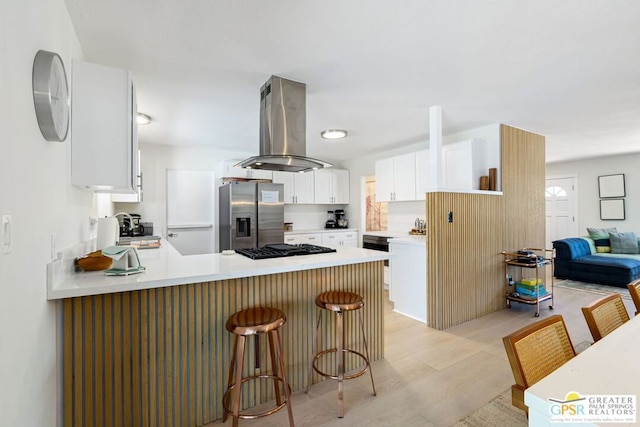 kitchen with a breakfast bar area, white cabinetry, island exhaust hood, stainless steel fridge with ice dispenser, and kitchen peninsula