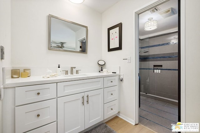 bathroom featuring an enclosed shower, vanity, and wood-type flooring